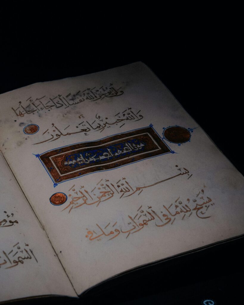 Open Quran page with intricate Arabic script and ornamentation, symbolizing Islamic faith and scripture.